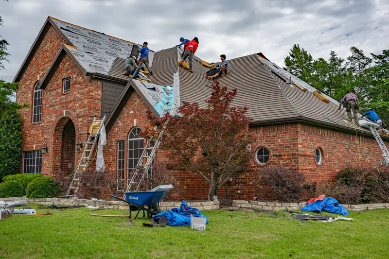 A roofing crew re-roofing a brick house